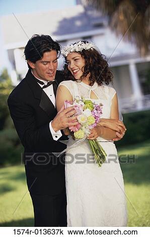 Close-up of a groom embracing his bride from behind View Large Photo Image Stock Image - Close-up of a groom embracing his bride from behind. Fotosearch