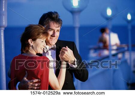 Stock Image - Close-up of a mature couple dancing on the deck of a cruise ship. Fotosearch