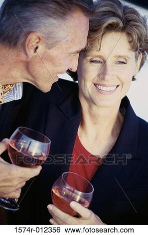 Stock Photograph - Close-up of a mature couple holding wineglasses. Fotosearch