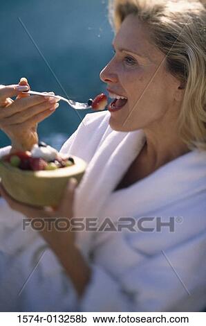 Close-up of a mature woman eating fruit salad View Large Photo Image Stock Image - Close-up of a mature woman eating fruit salad. Fotosearch