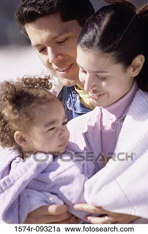 Stock Image - Close-up of a mother and father with their daughter. Fotosearch