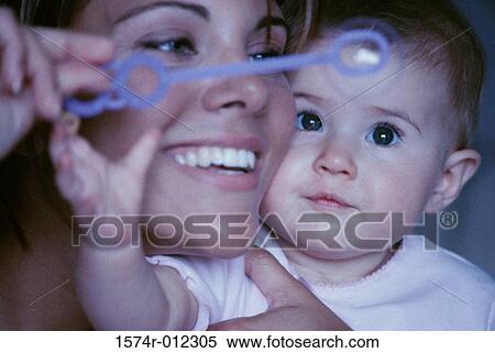 Close-up of a mother and son playing with a bubble wand View Large Photo Image Stock Photography - Close-up of a mother and son playing with a bubble wand. Fotosearch