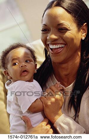 Stock Image - Close-up of a mother holding her son and laughing. Fotosearch