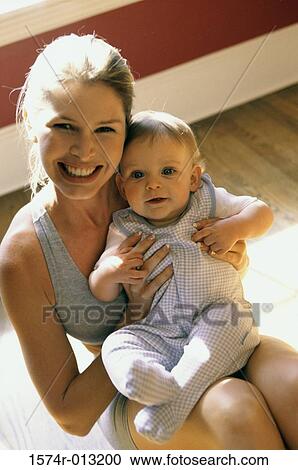 Close-up of a mother holding her son and smiling View Large Photo Image Stock Image - Close-up of a mother holding her son and smiling. Fotosearch