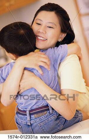 Close-up of a mother hugging her son View Large Photo Image Stock Image - Close-up of a mother hugging her son. Fotosearch