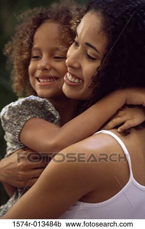 Stock Image - Close-up of a mother hugging her daughter. Fotosearch