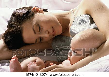 Picture - Close-up of a mother lying in bed with her son. Fotosearch