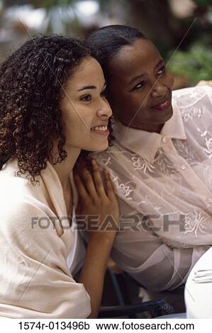 Stock Image - Close-up of a mother sitting with her daughter. Fotosearch