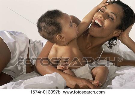 Close-up of a mother smiling with her son View Large Photo Image Stock Image - Close-up of a mother smiling with her son. Fotosearch