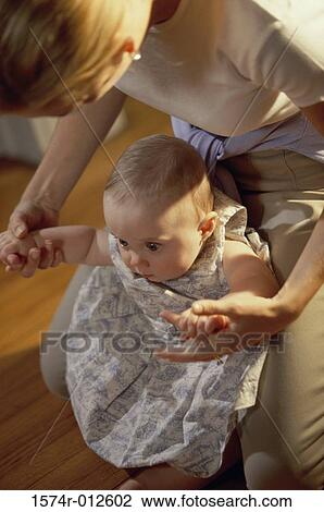 Stock Image - Close-up of a mother teaching her daughter to walk. Fotosearch