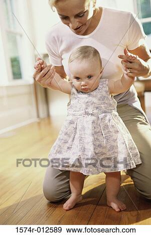Close-up of a mother teaching her daughter to walk View Large Photo Image Stock Photo - Close-up of a mother teaching her daughter to walk. Fotosearch