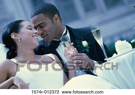 Close-up of a newlywed couple holding a champagne flute View Large Photo Image Stock Image - Close-up of a newlywed couple holding a champagne flute. Fotosearch