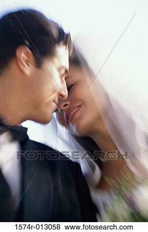 Stock Photo - Close-up of a newlywed couple kissing. Fotosearch