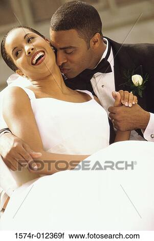 Stock Image - Close-up of a newlywed couple smiling. Fotosearch