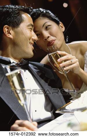 Stock Image - Close-up of a newlywed couple toasting with champagne. Fotosearch