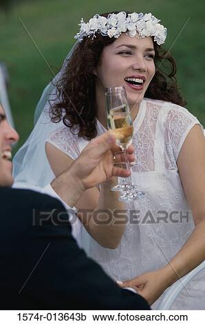 Stock Image - Close-up of a newlywed couple toasting with champagne. Fotosearch