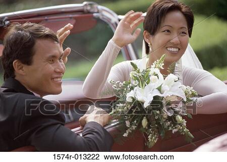 Close-up of a newlywed couple waving from a convertible car View Large Photo Image Stock Image - Close-up of a newlywed couple waving from a convertible car. Fotosearch