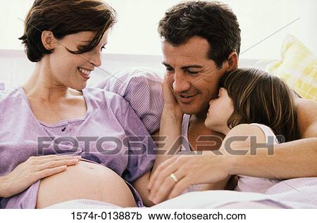 Stock Image - Close-up of a pregnant woman touching her abdomen. Fotosearch