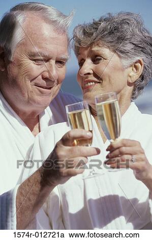 Close-up of a senior couple toasting with champagne flutes View Large Photo Image Stock Image - Close-up of a senior couple toasting with champagne flutes. Fotosearch