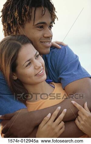 Close-up of a teenage boy embracing a teenage girl from behind View Large Photo Image Stock Image - Close-up of a teenage boy embracing a teenage girl from behind. Fotosearch