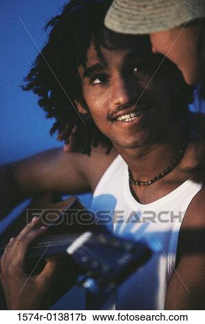 Stock Image - Close-up of a teenage boy playing a guitar. Fotosearch