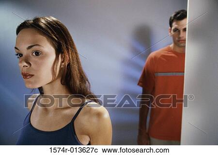 Stock Image - Close-up of a teenage girl with a teenage boy standing behind her. Fotosearch