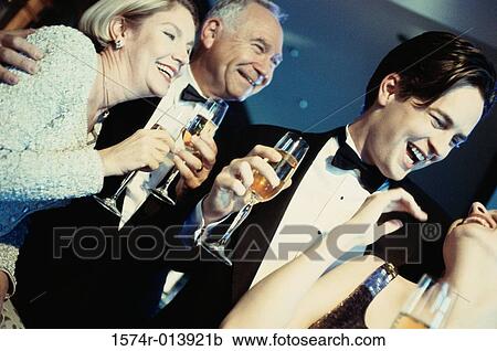 Close-up of a young couple and senior couple holding glasses of champagne at a bar View Large Photo Image Stock Image - Close-up of a young couple and senior couple holding glasses of champagne at a bar. Fotosearch