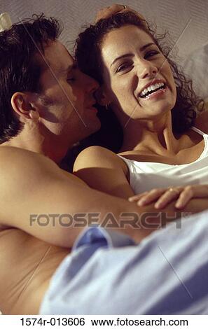 Close-up of a young couple embracing in bed View Large Photo Image Stock Photograph - Close-up of a young couple embracing in bed. Fotosearch