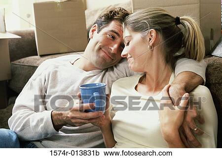 Stock Image - Close-up of a young couple holding a cup of coffee. Fotosearch