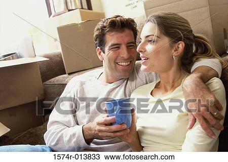 Close-up of a young couple holding a coffee cup sitting near cardboard boxes View Large Photo Image Stock Image - Close-up of a young couple holding a coffee cup sitting near cardboard boxes. Fotosearch