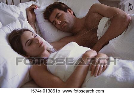 Close-up of a young couple sleeping in bed View Large Photo Image Stock Image - Close-up of a young couple sleeping in bed. Fotosearch