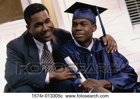 Stock Image - Close-up of a young male graduate sitting with his father. Fotosearch