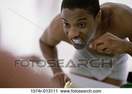 Close-up of a young man brushing his teeth View Large Photo Image Stock Image - Close-up of a young man brushing his teeth. Fotosearch
