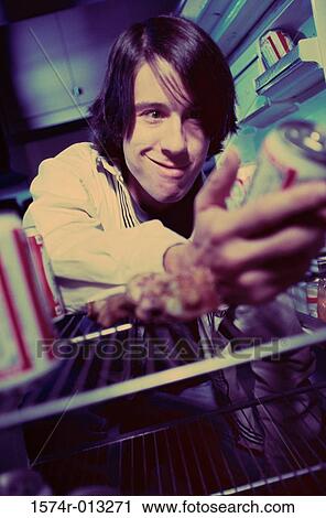 Close-up of a young man taking a beer can from a refrigerator View Large Photo Image Stock Image - Close-up of a young man taking a beer can from a refrigerator. Fotosearch
