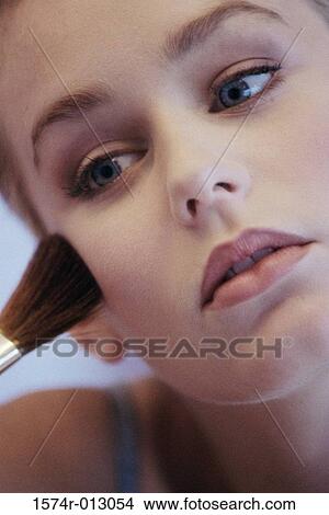 Close-up of a young woman applying blush with a make-up brush View Large Photo Image Picture - Close-up of a young woman applying blush with a make-up brush. Fotosearch