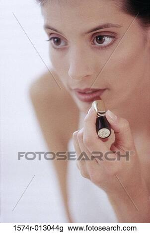 Close-up of a young woman applying lipstick to her lips View Large Photo Image Stock Image - Close-up of a young woman applying lipstick to her lips. Fotosearch