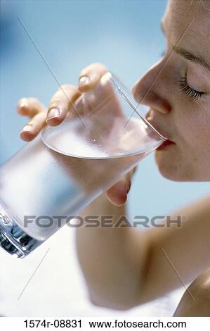 Close-up of a young woman drinking a glass of water View Large Photo Image Stock Image - Close-up of a young woman drinking a glass of water. Fotosearch