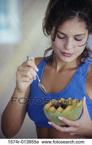 Close-up of a young woman eating a cantaloupe with grapes View Large Photo Image Stock Image - Close-up of a young woman eating a cantaloupe with grapes. Fotosearch