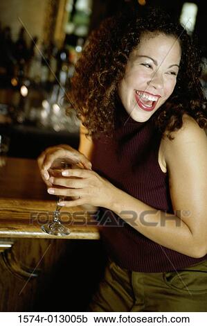 Close-up of a young woman laughing at a bar View Large Photo Image Stock Image - Close-up of a young woman laughing at a bar. Fotosearch