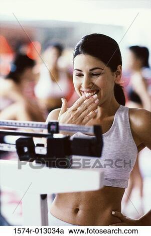 Close-up of a young woman standing on a weight scale View Large Photo Image Stock Image - Close-up of a young woman standing on a weight scale. Fotosearch