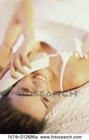 Close-up of a young woman talking on the telephone View Large Photo Image Stock Image - Close-up of a young woman talking on the telephone. Fotosearch