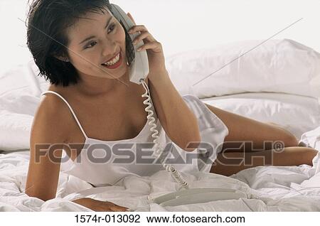 Stock Image - Close-up of a young woman talking on the telephone. Fotosearch