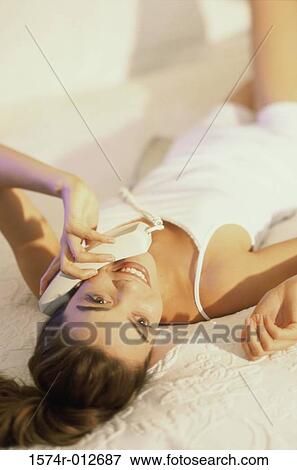 Close-up of a young woman talking on the telephone View Large Photo Image Stock Photo - Close-up of a young woman talking on the telephone. Fotosearch