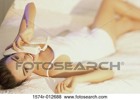 Close-up of a young woman talking on the telephone View Large Photo Image Stock Photo - Close-up of a young woman talking on the telephone. Fotosearch