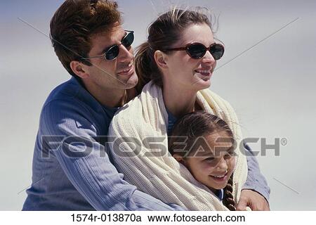 Stock Image - Close-up of parents and their daughter smiling. Fotosearch