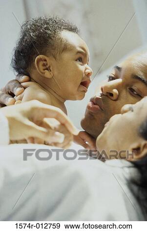 Stock Photo - Close-up of parents consoling their crying daughter. Fotosearch