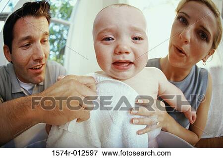 Close-up of parents giving their son a bath View Large Photo Image Stock Photo - Close-up of parents giving their son a bath. Fotosearch