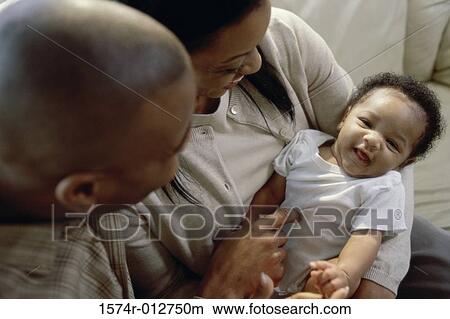 Close-up of parents holding their son View Large Photo Image Picture - Close-up of parents holding their son. Fotosearch