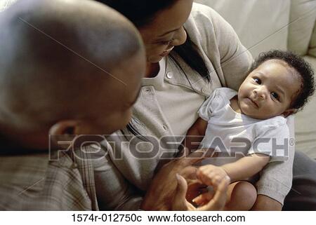 Stock Image - Close-up of parents holding their son. Fotosearch