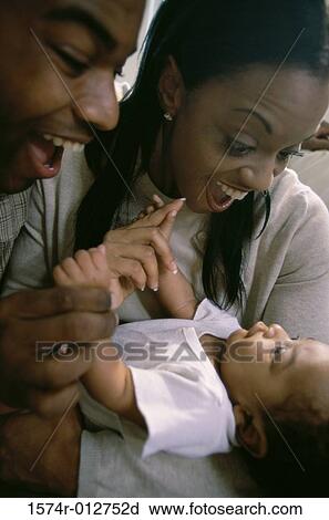 Stock Image - Close-up of parents holding their son. Fotosearch
